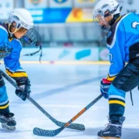 two kids are playing hockey and using amazing accessories